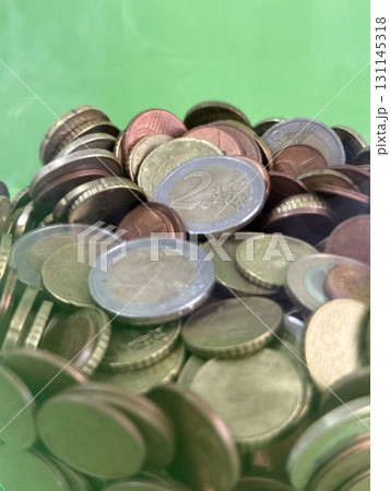 A close-up of euro coins falling into a container. Saving money to buy necessary things. A close-up of euro coins falling into a container. Saving money to buy necessary things. 131145318