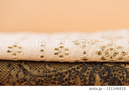 Folded lace fabrics, close up, cream and gold 131146818