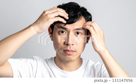 薄毛を気にする若い男性(AI生成画像) 薄毛を気にする若い男性(AI生成画像) 131147056
