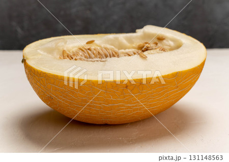 Half yellow melon with visible seeds on white surface Half yellow melon with visible seeds on white surface 131148563