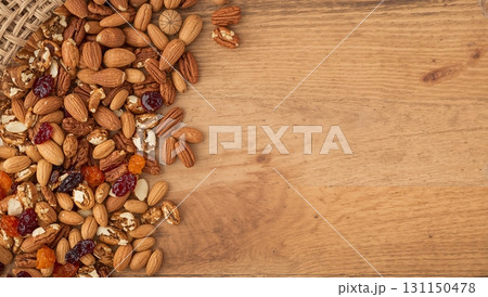 A bowl of nuts and raisins on a wooden table 131150478