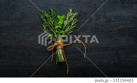 A bunch of herbs are tied together and placed on a wooden surface A bunch of herbs are tied together and placed on a wooden surface 131150483