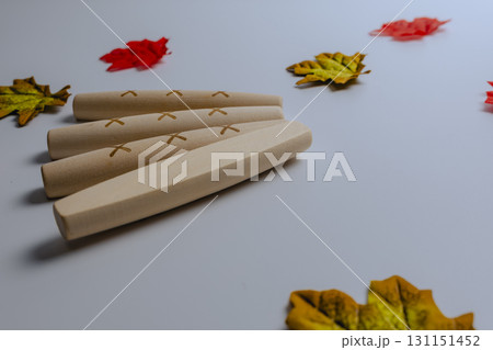 Autumn leaves surround the yut stones of the traditional Korean game of Yut Nori. Close-up. Side view. 131151452