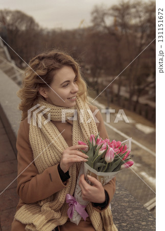 Close-up of a blonde with a bouquet of pink tulips. 131151672