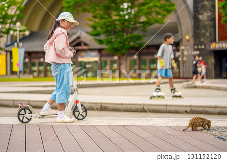 Asian girl is going to ride a scooter. Meerkat. Copy space 131152120