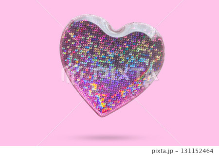 Pink heart shape hologram sticker flying on pink background 131152464