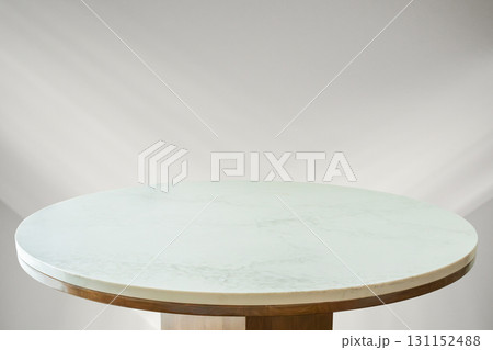 Round marble table top with abstract shadow drop on white wall background for mockup product display 131152488