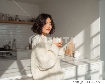 キッチンでやわらかな光に包まれる女性 131152770