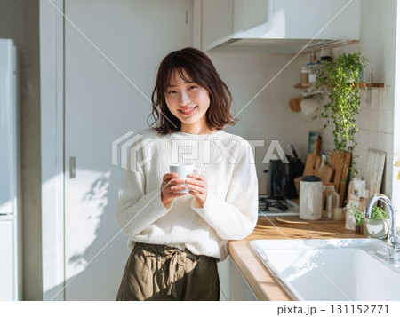 グリーンに囲まれたキッチンで過ごす女性 131152771