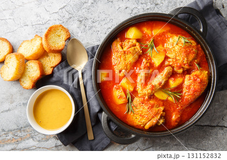 Chicken Bouillabaisse is comforting stew featuring tender chicken pieces simmered in a saffron-tomato broth infused with garlic, fennel, and white wine closeup. Horizontal top view 131152832