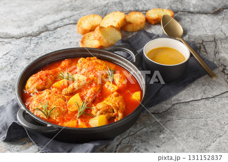Chicken Bouillabaisse cooked in a delicious rich and fragrant broth closeup in the saucepan. Horizontal 131152837