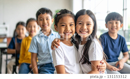 Children laughing and playing together in a lively classroom setting during a group activity focused on friendship and teamwork 131153312