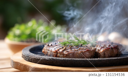 Sizzling steak on a hot stone with fresh herbs, showcasing the return of meat consumption 131154536