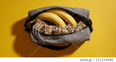 A gym bag spills out bananas and granola bars, showcasing a focus on fiber-rich food for wellness 131154890