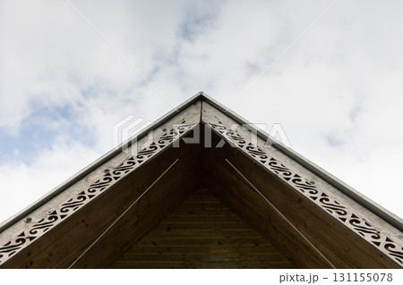 A close-up view of a wooden roof gable featuring intricate decorative trim 131155078