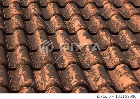 Close-up view of old terracotta roof tiles showing patina and rust marks Close-up view of old terracotta roof tiles showing patina and rust marks 131155086