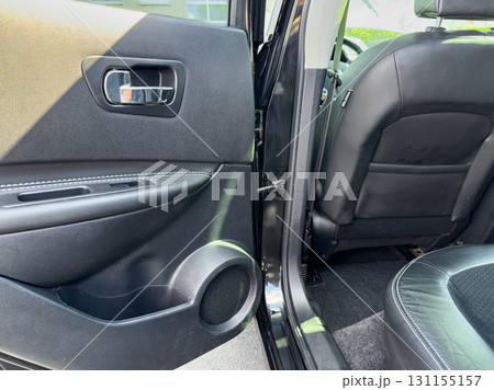 Interior view of a modern car showing the door panel and rear seat in bright daylight in a suburban area Interior view of a modern car showing the door panel and rear seat in bright daylight in a suburban area 131155157