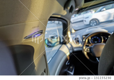 Detailed view of car interior featuring airbag symbol, steering wheel and sunlight illuminating dashboard during late afternoon drive Detailed view of car interior featuring airbag symbol, steering wheel and sunlight illuminating dashboard during late afternoon drive 131155230