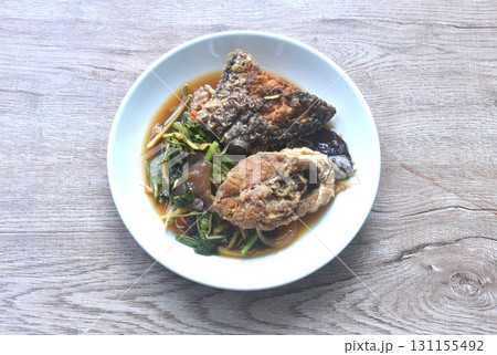 spicy deep fried chop Nile Tilapia or mango fish slice ginger and ear mushroom couple celery dressing soy sauce on plate  131155492