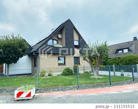 Modern suburban house with a fenced yard and lush greenery near residential area in a calm neighborhood 131155515