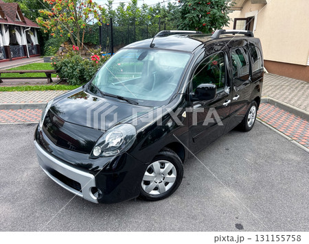 A sleek and stylish black compact city car is parked in a picturesque location surrounded by vibrant lush greenery, contributing to a welcoming and cozy ambiance thats truly captivating A sleek and stylish black compact city car is parked in a picturesque location surrounded by vibrant lush greenery, contributing to a welcoming and cozy ambiance thats truly captivating 131155758