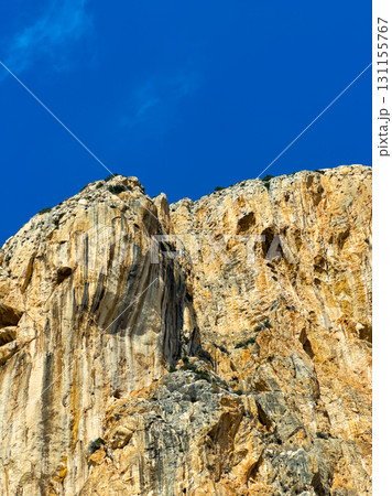 Stunning rock formation under a clear blue sky in a mountainous landscape during a sunny day 131155767