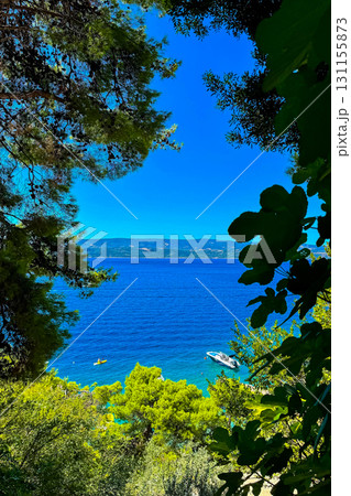 Serene coastal escape revealing stunning azure waters framed by lush greenery and distant hills in bright daylight Serene coastal escape revealing stunning azure waters framed by lush greenery and distant hills in bright daylight 131155873