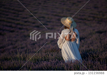 Lavender Field Woman Dress: Sunset Provence France, summer, photography; woman admires scenic purple blossoms. Lavender Field Woman Dress: Sunset Provence France, summer, photography; woman admires scenic purple blossoms. 131156988