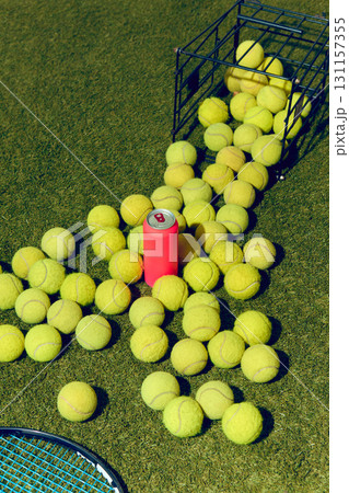 Pink mockup can surrounded by scattered tennis balls on grass court Pink mockup can surrounded by scattered tennis balls on grass court 131157355