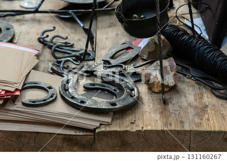 blacksmith's counter horseshoe, symbol of good luck, bowler hat on wooden table background 131160267
