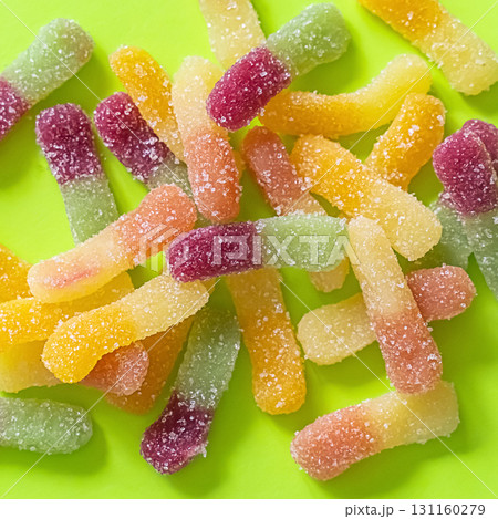 gummy candy worms sprinkled with sugar on a green background 131160279