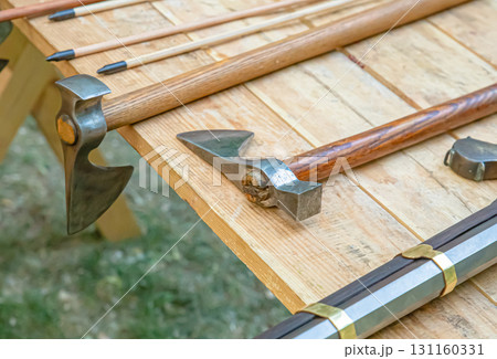 battle ax and rifle stacked in a row, various weapons on the table selective focus 131160331