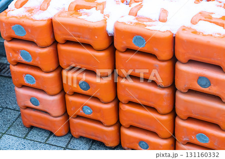 wall of plastic gasoline cans orange stacked in a row covered with snow 131160332