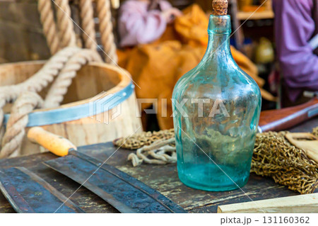 blue glass bottle stands on a table on a blurred background of a barrel blue glass bottle stands on a table on a blurred background of a barrel 131160362