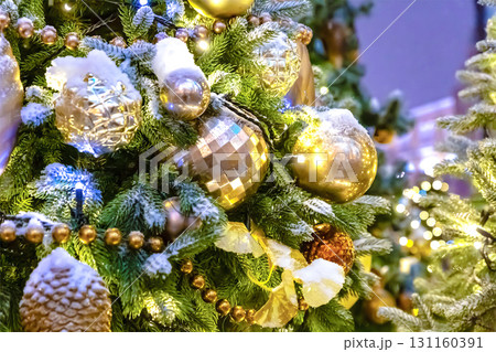 brightly decorated christmas tree with golden big balls and covered with snow brightly decorated christmas tree with golden big balls and covered with snow 131160391