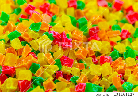 A close-up of a pile of candied fruit pieces. Sweet dried pineapple, orange, and papaya are used as fillings in confectionery and as an addition to breakfast muesli. 131161127