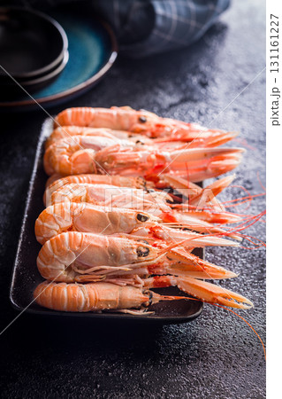 Scampi langoustine on plate on black table. 131161227