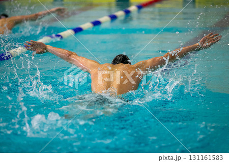 Two swimmers performing butterfly stroke at swimming competition 131161583