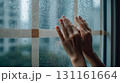 夜の雨の日室内窓に手を添える人 131161664