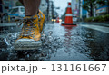 一人、雨の日の都市歩道で水を跳ねる黄色い靴 131161667