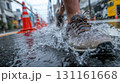 都会の昼間の雨の日、路上でブーツが水たまりを踏む 131161668