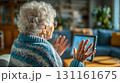 自宅リビングで昼間オンライン通話する高齢女性 131161675