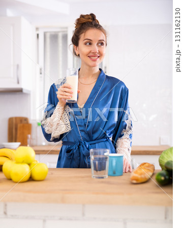 Positive woman drinking dairy product at home 131162130