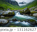 The beautiful landscape of a green valley in spring season with stream water flowing through the boulders. 131162627