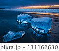 The ices on wet black sand beach in the evening with the sea waves crashing the shores. 131162630