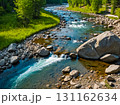 Aerial view of beautiful small stream flowing pass boulders in the green forest in spring season. 131162634