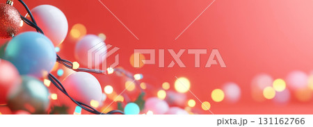 Colorful Christmas lights and ornaments on red background 131162766