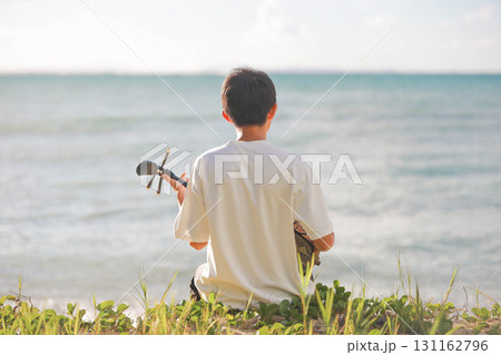 海岸で三線を奏でる少年 海岸で三線を奏でる少年 131162796