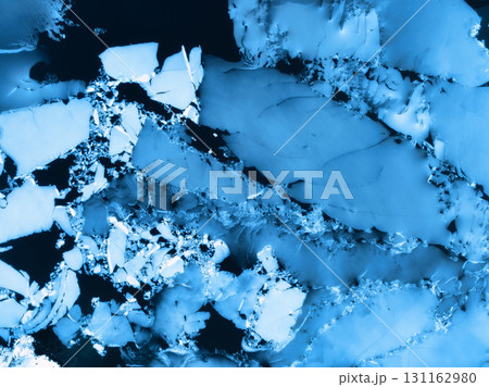 Aerial drone view of cracked ice floes on frozen lake surface 131162980