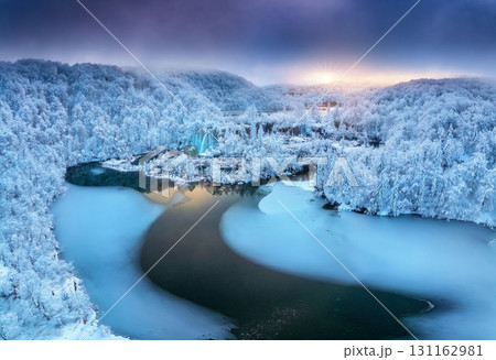 Aerial view of frozen lakes, waterfalls and snowy forest. Winter 131162981